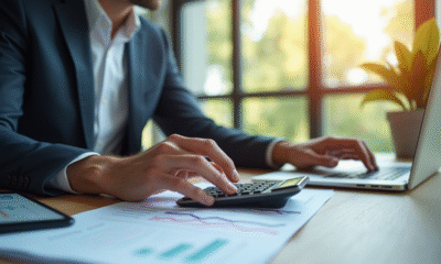 Comptable au bureau utilisant calculatrice et ordinateur pour la gestion financière
