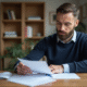 Homme lisant des papiers à la maison dans un intérieur organisé