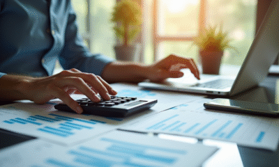 Personne d'affaires au bureau utilisant calculatrice et ordinateur