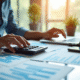 Personne d'affaires au bureau utilisant calculatrice et ordinateur